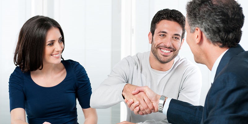 Smiling couple man shaking hands with sales agent