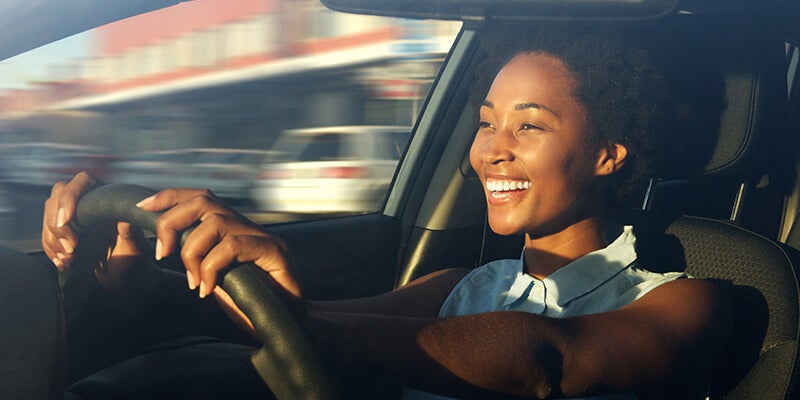 Woman driving a car and smiling