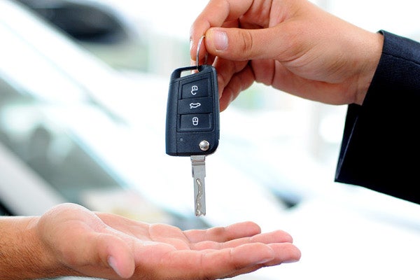 A person handing a car key to another person