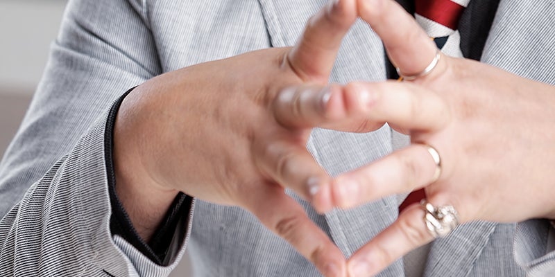 Business man clasping hands in serious manner