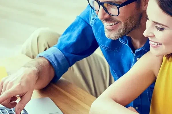 Man and woman looking at lap top for online shopping