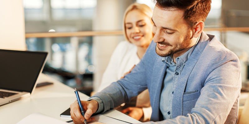 Man smiling singing papers