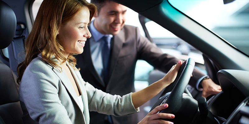 woman in drivers seat getting ready to test drive a car