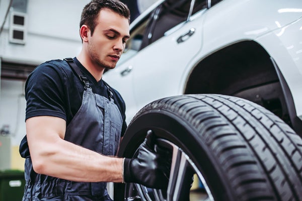 Mechanic holding a tire to put on car in shop