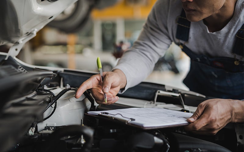 Technician inspecting a car